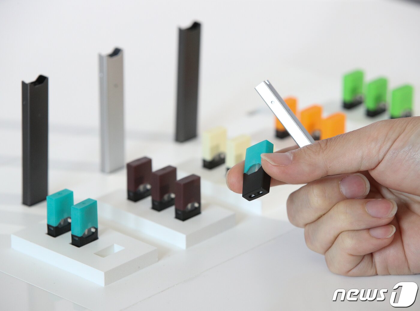 본문 이미지 - 22일 오전 서울 성동구 어반소스에서 열린 전자담배 쥴 출시 관련 기자간담회에서 참석자들이 쥴 디바이스를 살펴보고 있다. 오는 24일 서울 편의점과 면세점 등에서 만날 수 있는 쥴 디바이스는 고유의 온도 조절 시스템이 적용돼 성인 흡연자들에게 일반 담배와 유사한 수준의 만족감을 제공하며 연기와 재로부터 자유로워 깔끔한 사용이 가능하다. 2019.5.22/뉴스1 ⓒ News1 신웅수 기자