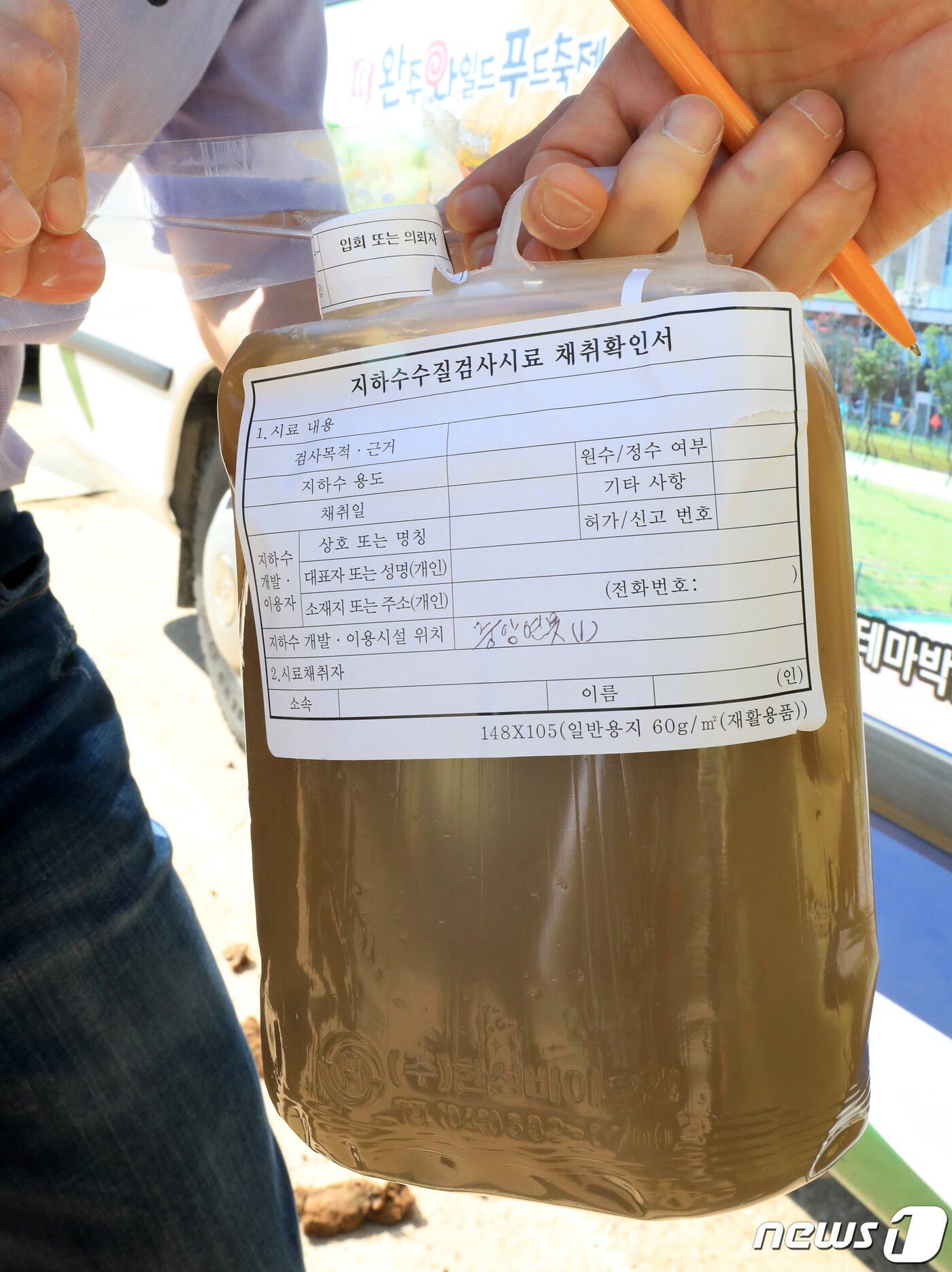 본문 이미지 - 지난달 23일 오후 침출수 유출 문제가 발생한 전북 완주군 (유)보은매립장에서 현장 조사를 나온 군의원 등이 검사를 위해 채취한 침출수를 봉인하고 있다. .2019.5.23 /뉴스1 ⓒ News1
