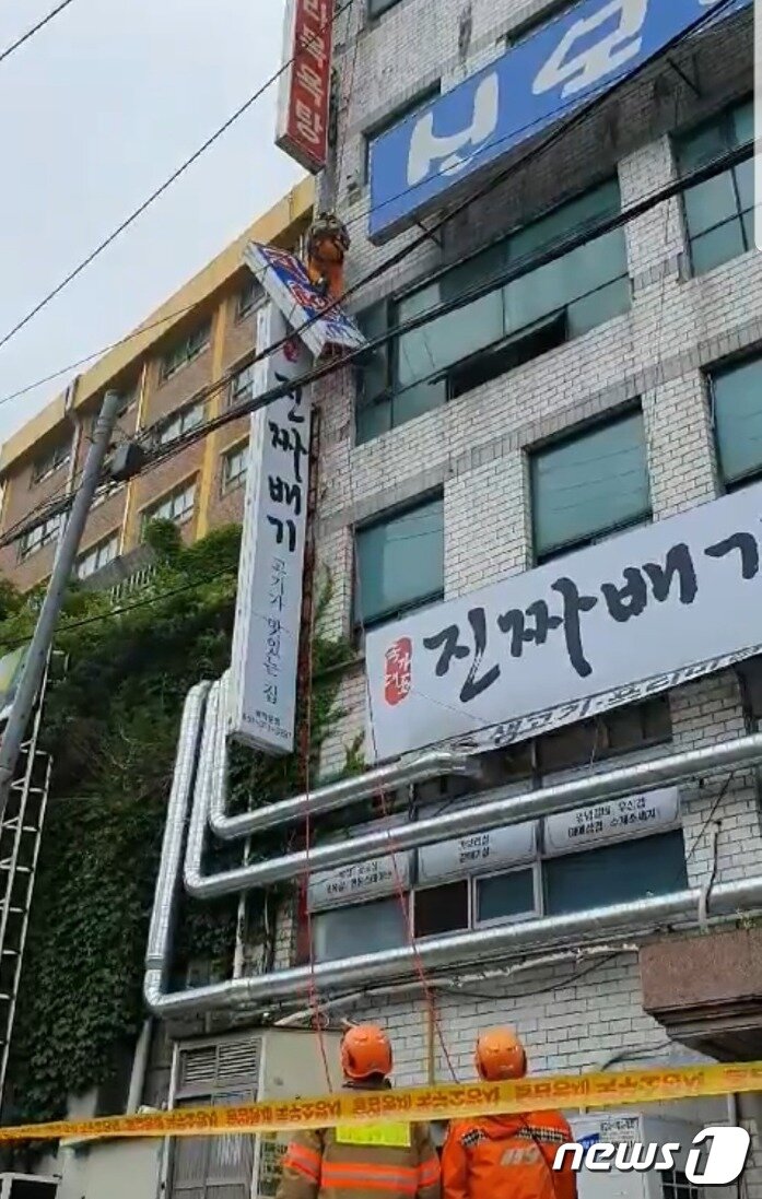 본문 이미지 - 27일 오후 12시51분쯤 부산 사상구 모라동의 한 목욕탕 간판이 강풍에 휘날려 소방대원들이 제거작업을 벌이고 있다.(부산소방재난본부 제공)ⓒ 뉴스1