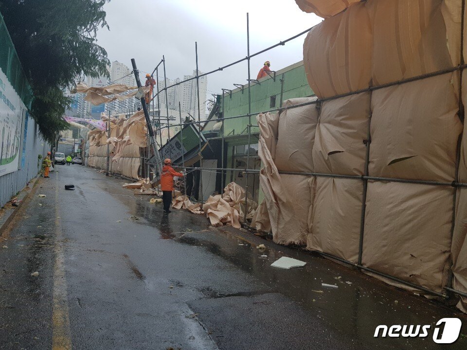 본문 이미지 - 27일 오후 12시30분쯤 부산 사상구 덕포1구역 재개발지역 비계가 쓰러져 통신주가 넘어졌다. 소방대원들이 안전조치를 하고있다.(부산지방경찰청 제공)ⓒ 뉴스1