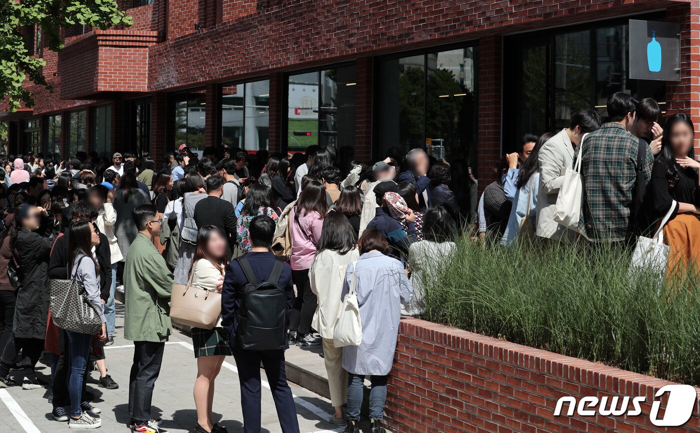 본문 이미지 - 3일 오전 서울 성동구에 개점한 블루보틀(Blue Bottle) 1호점을 찾은 시민들이 줄을 서 있다. 성수점에서는 앞으로 엄선한 블렌드와 싱글 오리진 드립 커피·아이스 커피·에스프레소 음료 등 커피 메뉴를 판매한다. 또 국내 파티시에 '메종엠모'(Maison MO)와 협업해 만든 국내 한정 페이스트리 메뉴를 제공한다. 2019.5.3/뉴스1 ⓒ News1 이재명 기자
