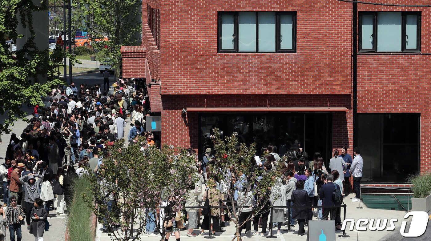 본문 이미지 - 3일 오전 서울 성동구에 개점한 블루보틀(Blue Bottle) 1호점을 찾은 시민들이 줄을 서 있다. 성수점에서는 앞으로 엄선한 블렌드와 싱글 오리진 드립 커피·아이스 커피·에스프레소 음료 등 커피 메뉴를 판매한다. 또 국내 파티시에 '메종엠모'(Maison MO)와 협업해 만든 국내 한정 페이스트리 메뉴를 제공한다. 2019.5.3/뉴스1 ⓒ News1 이재명 기자