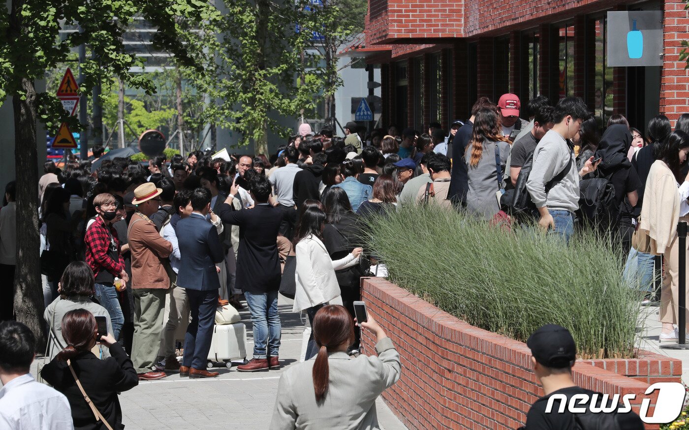 본문 이미지 - 3일 오전 서울 성동구에 개점한 블루보틀(Blue Bottle) 1호점을 찾은 시민들이 줄을 서 있다. 성수점에서는 앞으로 엄선한 블렌드와 싱글 오리진 드립 커피·아이스 커피·에스프레소 음료 등 커피 메뉴를 판매한다. 또 국내 파티시에 '메종엠모'(Maison MO)와 협업해 만든 국내 한정 페이스트리 메뉴를 제공한다. 2019.5.3/뉴스1 ⓒ News1 이재명 기자