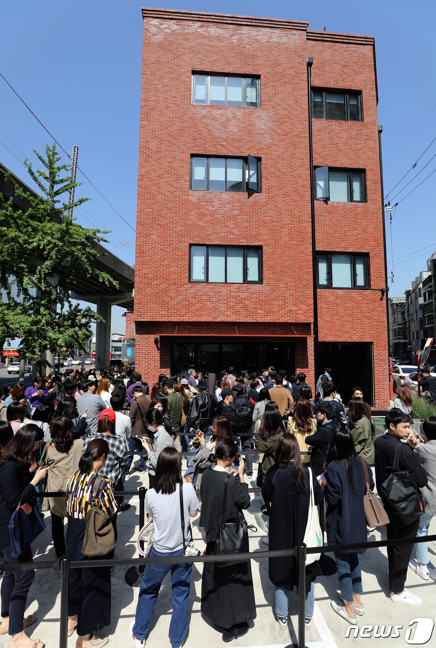 본문 이미지 - 3일 오전 서울 성동구에 개점한 블루보틀(Blue Bottle) 1호점을 찾은 시민들이 줄을 서 있다. 성수점에서는 앞으로 엄선한 블렌드와 싱글 오리진 드립 커피·아이스 커피·에스프레소 음료 등 커피 메뉴를 판매한다. 또 국내 파티시에 '메종엠모'(Maison MO)와 협업해 만든 국내 한정 페이스트리 메뉴를 제공한다. 2019.5.3/뉴스1 ⓒ News1 이재명 기자