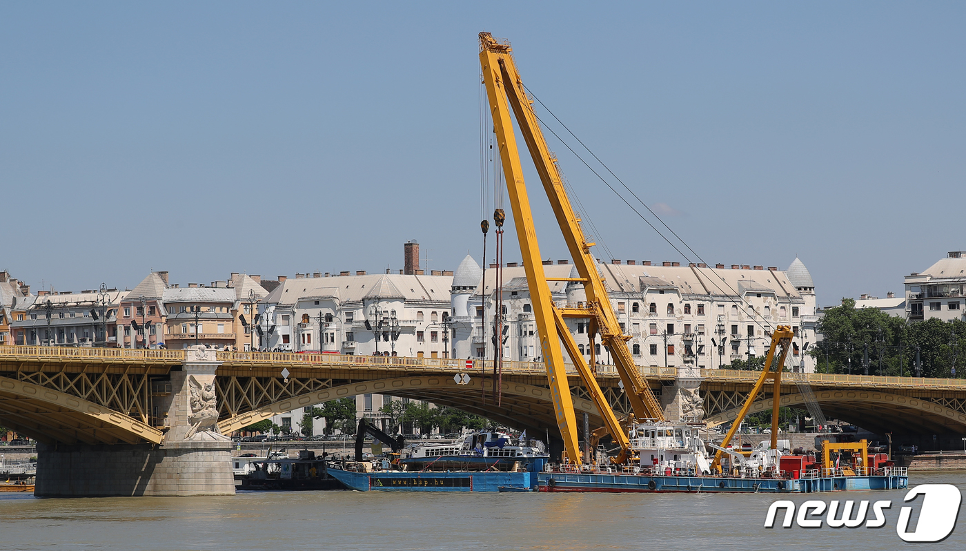 (부다페스트(헝가리)=뉴스1) 구윤성 기자 = 11일 오후(현지시간) 헝가리 부다페스트 다뉴브강 머르기트 다리 인근에서 인양된 유람선 '허블레아니호'가 바지선으로 옮겨지고 있다. …