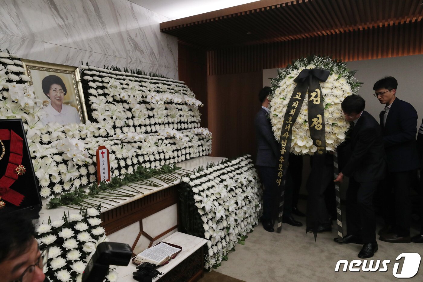 본문 이미지 - 12일 저녁 서울 서대문구 연세세브란스병원 장례식장에 마련된 고 이희호 김대중평화센터 이사장 빈소에 관계자들이 김정은 북한 국무위원장이 보낸 조화를 놓고 있다. 2019.6.12/뉴스1 ⓒ News1 이광호 기자