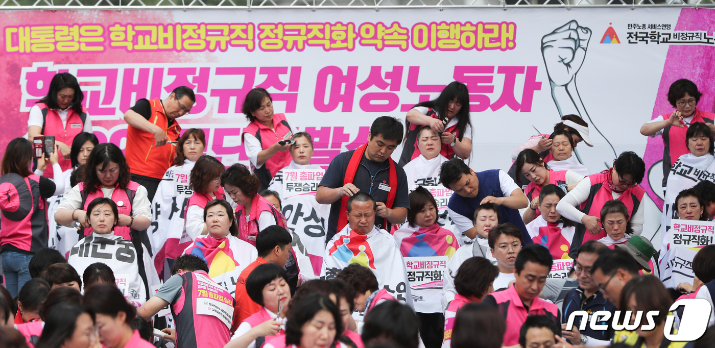 (서울=뉴스1) 허경 기자 = 급식조리원 등 학교비정규직노동자 100명이 17일 서울 종로구 청와대 사랑채 인근에서 기자회견을 열고 임금인상 등을 요구하며 단체로 삭발을 하고 있다 …