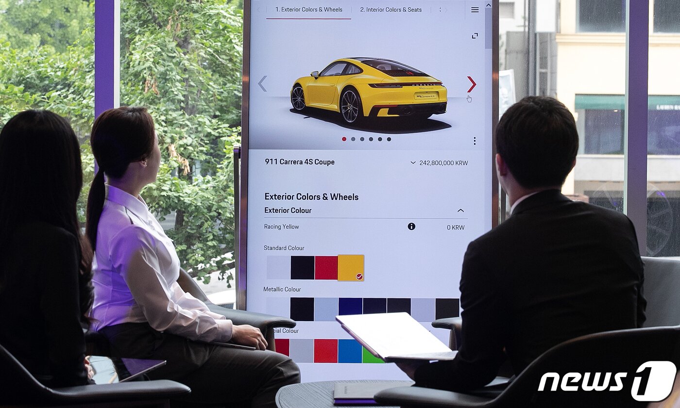본문 이미지 - 18일 오전 서울 강남구 포르쉐 스튜디오 청담에서 관계자들이 차량 옵션 적용을 화면으로 지켜보고 있다. 포르쉐 스튜디오 청담은 세계 여덟 번째로 문을 연 포르쉐 스튜디오로 기존의 전시관 형태를 벗어나 다양한 영역의 브랜드 경험을 제공한다. 2019.6.18/뉴스1 ⓒ News1 이승배 기자