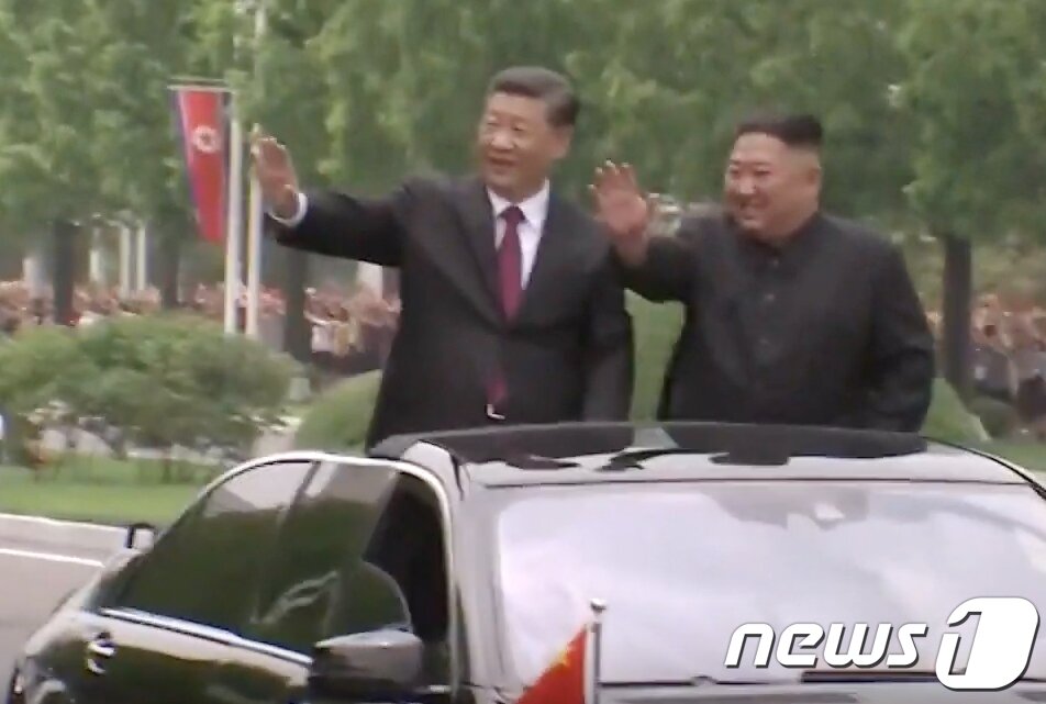 본문 이미지 - 시진핑 중국 국가주석이 김정은 국무위원장과 함께 금수산 태양궁전으로 향하며 환호하는 평양시민들을 향해 손인사를 하고 있다. (CCTV 화면 캡쳐)2019.6.20/뉴스1