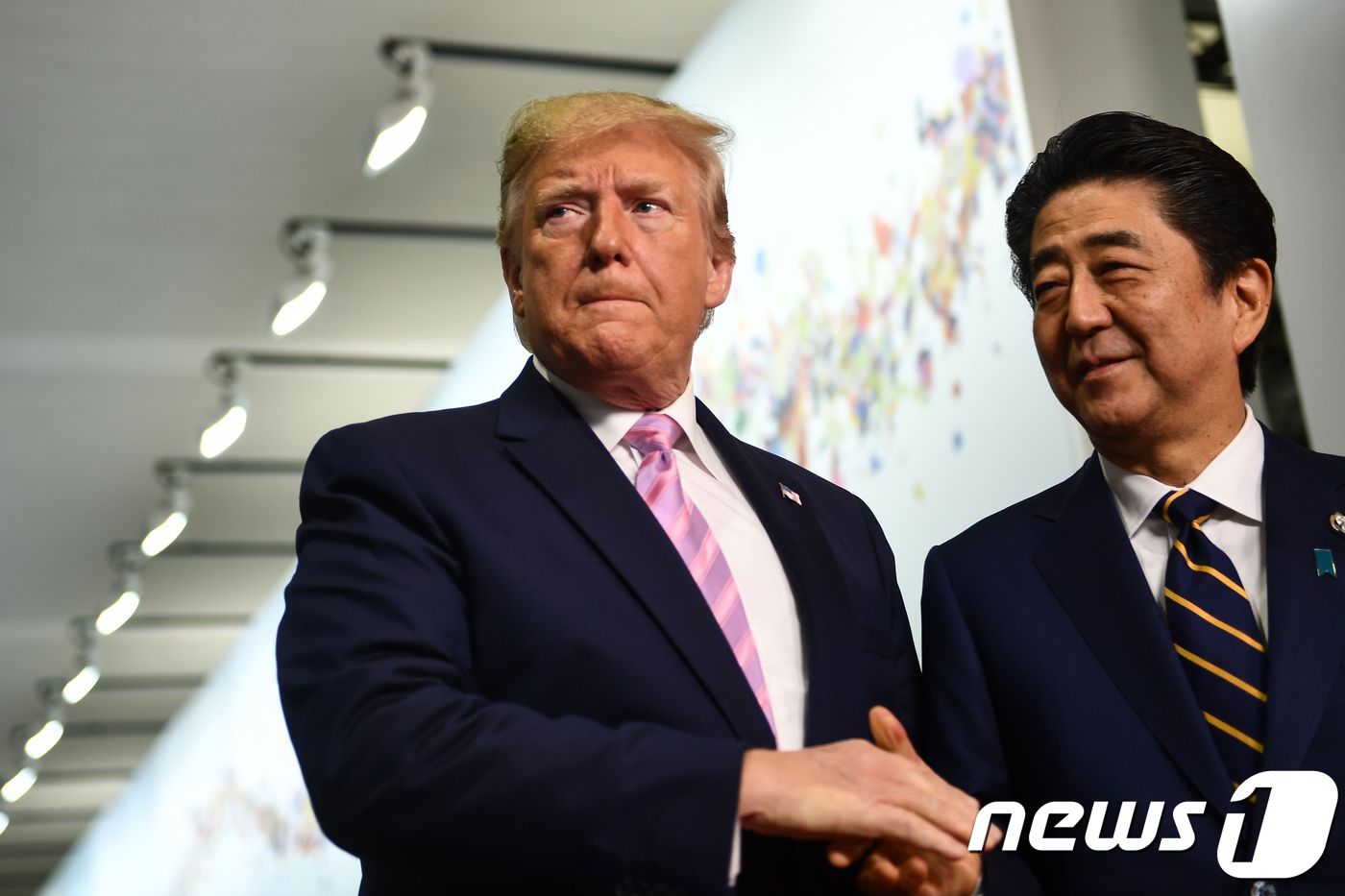 (오사카 AFP=뉴스1) 우동명 기자 = 도널드 트럼프 미국 대통령이 28일(현지시간) 오사카 G20 정상회의에서 아베 신조 일본 총리와 악수를 하고 있다.ⓒ AFP=뉴스1