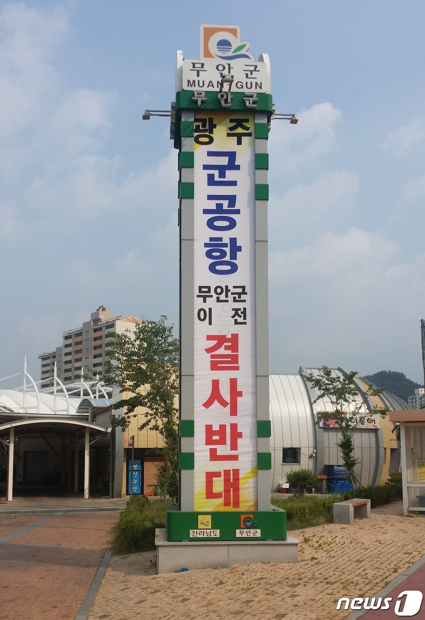 본문 이미지 - 무안군이 지역 주요 관문과 번화가에 설치한 ‘군 공항 이전 결사 반대’ 문구가 게시된 10m높이의 대형 홍보탑(무안군 제공) 2019.6.30 /뉴스1 ⓒ News1