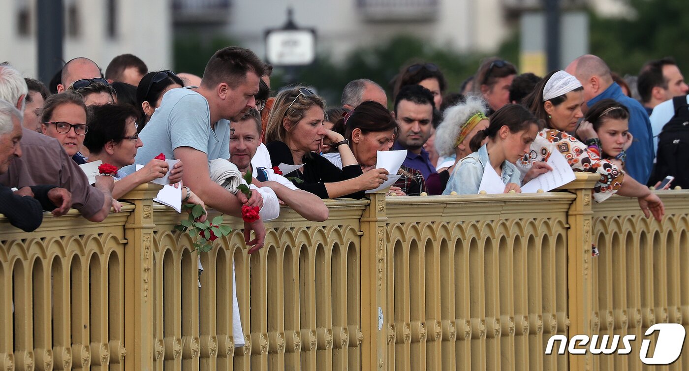 본문 이미지 - 헝가리 부다페스트 다뉴브강 유람선 침몰사고 엿새째인 3일 오후(현지시간) 다뉴브강 머르기트 다리에 모인 헝가리 시민들이 '허블레아니호' 사고 희생자에 대한 추모와 실종자의 무사귀환을 기원하며 '아리랑'을 부르고 있다. 2019.6.4/뉴스1 ⓒ News1 구윤성 기자