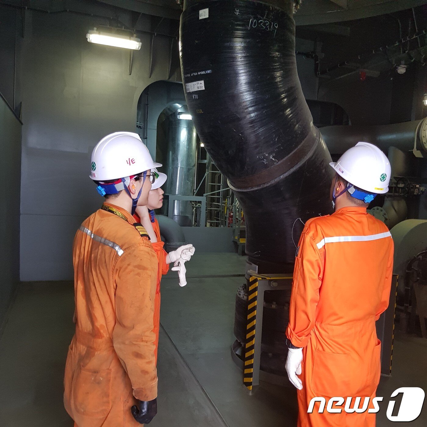 본문 이미지 - 프로미스호 김지수 1등기관사(왼쪽)가 스크러버 배수관 등에 대해 설명하고 있는 모습. (현대상선 제공)ⓒ 뉴스1