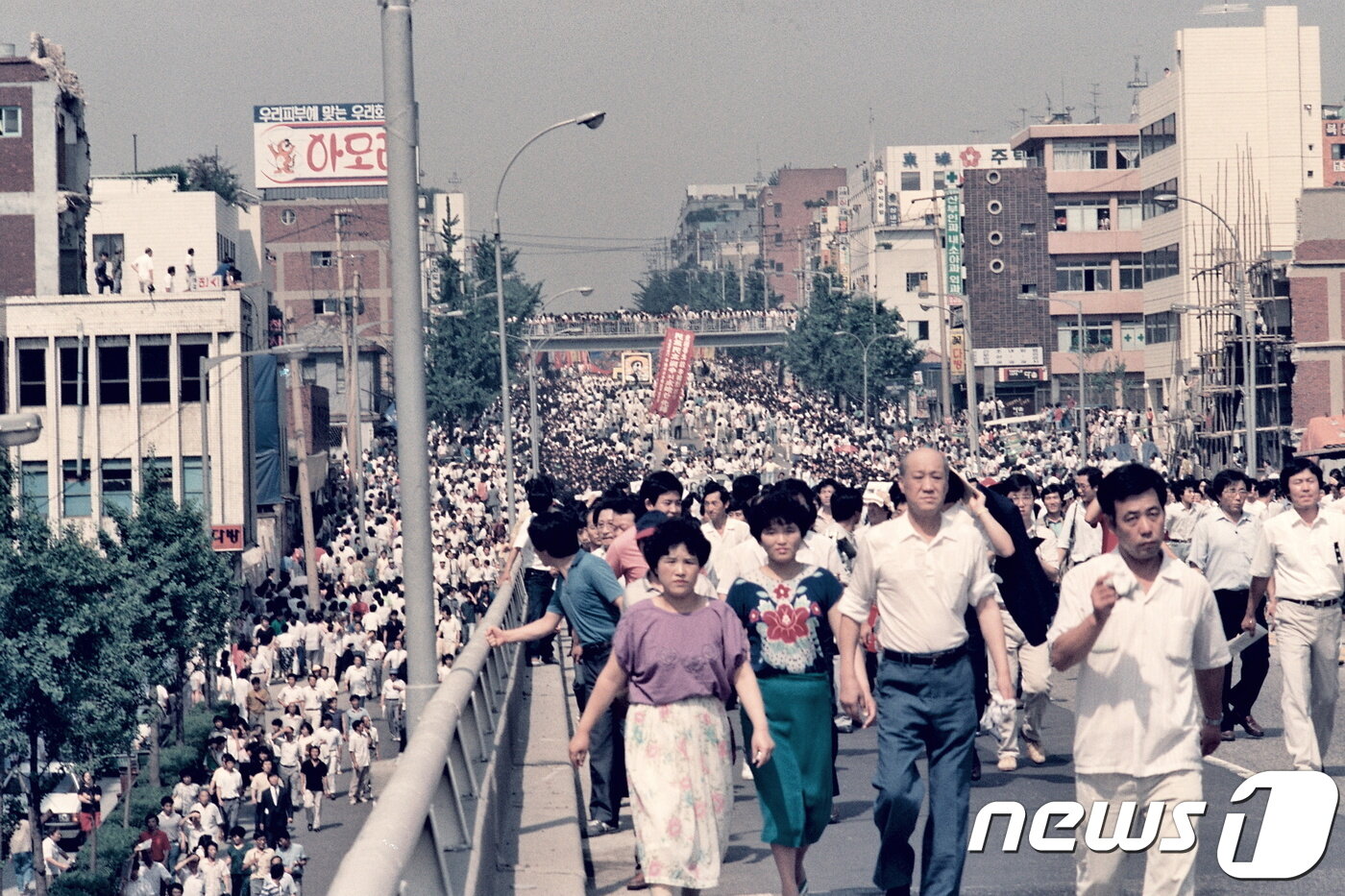 본문 이미지 - 1987년 5월9일 이한열 열사 장례식 당시 운구 차량 이동을 지켜보려는 인파가 거리로 나왔다. 멀리로 아현고가 밑을 지나는 운구차량이 보인다. (이한열 기념사업회 제공) ⓒ 뉴스1