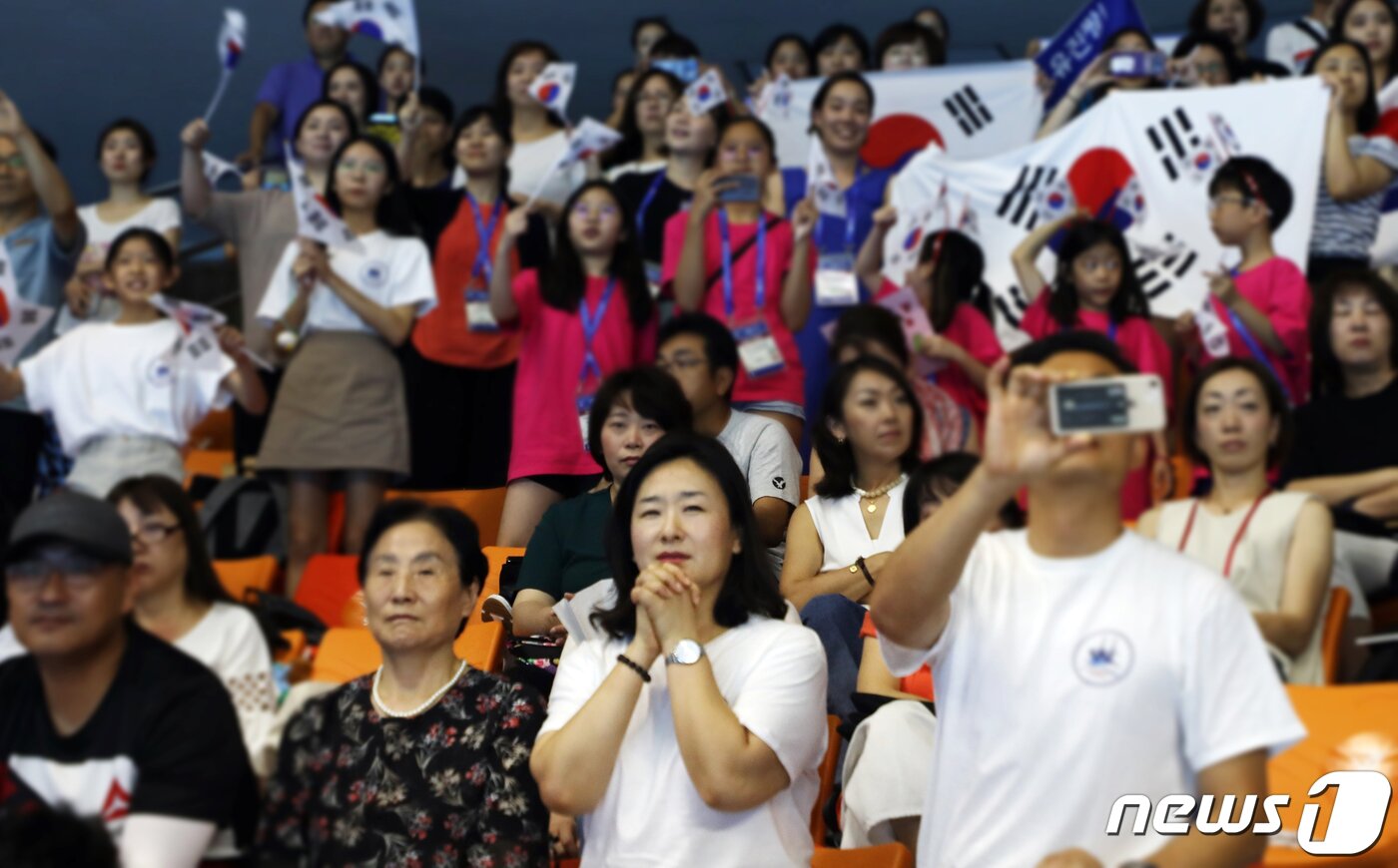 본문 이미지 - 신정윤씨 어머니 김혜진씨(45. 앞줄 오른쪽 두 번째)가 18일 오전 광주 서구 염주종합체육관 아티스틱수영경기장에서 프리 콤비네이션 종목에 출전한 선수들을 긴장한 모습으로 바라보고 있다.2019.7.18/뉴스1 ⓒ News1 허단비 기자