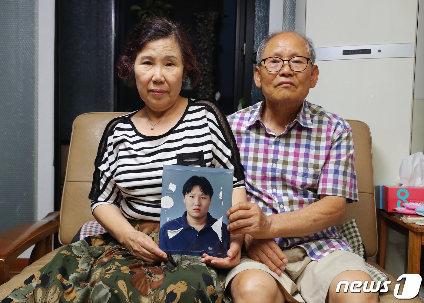 본문 이미지 - 실종된 강문상 씨의 아버지 강길수, 어머니 박예서 씨가 강 씨의 사진을 들고 있다. 군 제대 후 찾아온 정신장애 판정을 받은 강 씨(당시 26세)는 지난 2002년 11월 12일 서울 관악구 신림8동에서 저녁식사 후 나간 뒤 사라졌다. 2019.7.4/뉴스1 ⓒ News1 구윤성 기자