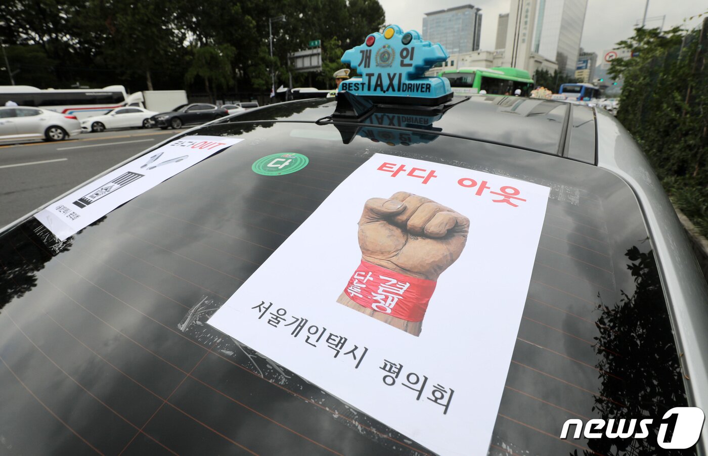 본문 이미지 - 13일 오전 중구 시청 앞 서울광장에서 열린 타다 운행정지 및 증차금지 촉구 집회에 참석한 서울개인택시평의회 운전자들의 차량에 '타다 아웃' 스티커가 붙어 있다. 2019.8.13/뉴스1 ⓒ News1 박세연 기자