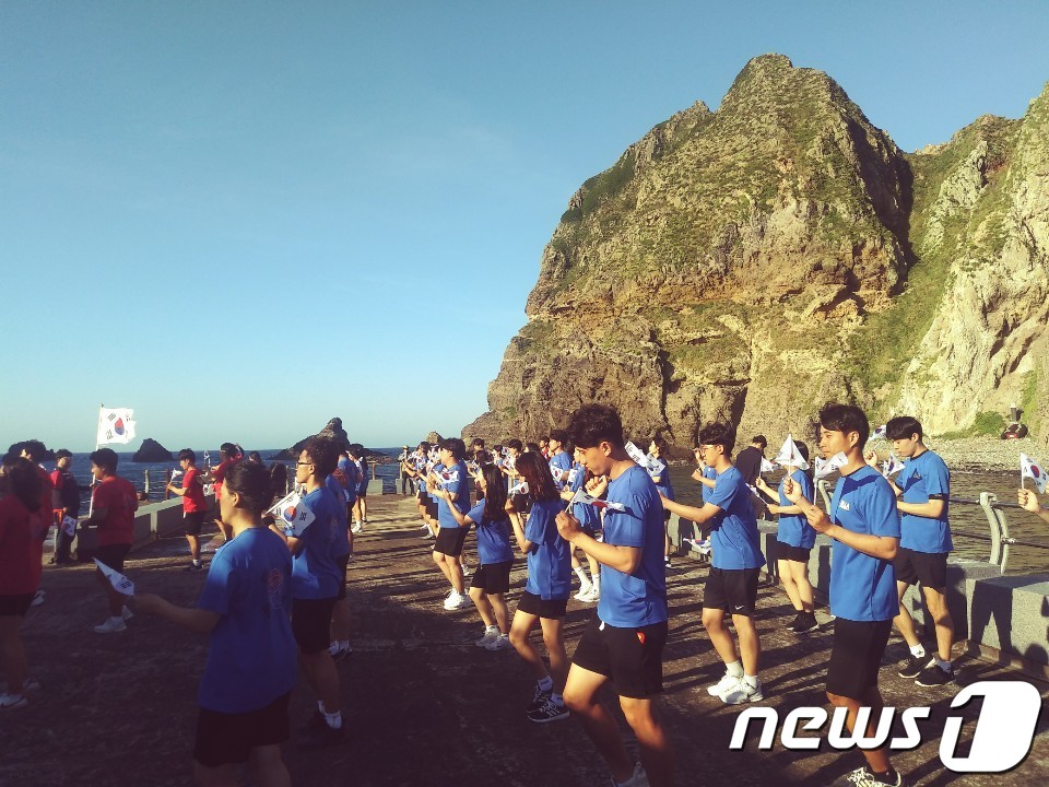 (독도=뉴스1) 이기창 기자 = 국토 대장정길에 오른 부산 신라대 학생들이 지난 13일 오후 독도의 동쪽섬 동도에서 '독도는 우리땅' 플래시몹을 펼치고 있다.당초 광복절 당일 입도 …