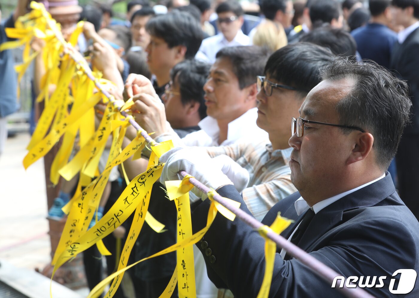 본문 이미지 - 17일 오전 청주고인쇄박물관에 위치한 고(故) 민준영(당시 36세)·박종성 대원(당시 42세)의 추모비 앞에서 유가족 등이 노란 리본을 달고 있다. 2019.8.17/뉴스1 ⓒ News1 김용빈 기자