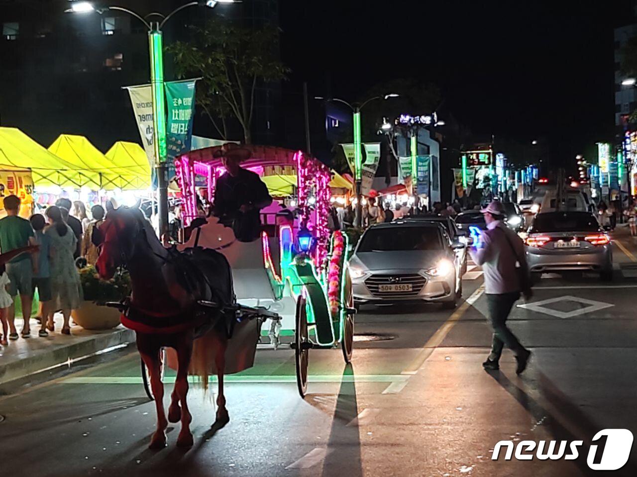 본문 이미지 - 지난 1일 속초해수욕장에서 마차가 차량과 피서객들이 한 데 뒤섞여 운행을하고 있다. ⓒ News1 홍성우 기자