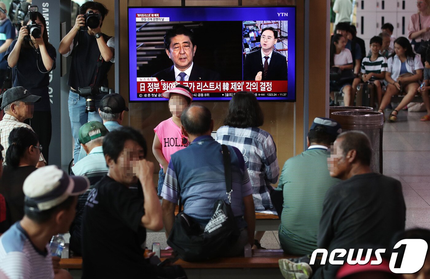 본문 이미지 - 일본이 한국을 전략물자 수출심사 우대국&#40;화이트리스트&#41;에서 제외하는 수출무역관리령 개정안을 처리한 2일 서울 중구 서울역 대합실에서 시민들이 뉴스 속보를 지켜보고 있다. 2019.8.2/뉴스1 ⓒ News1 오대일 기자