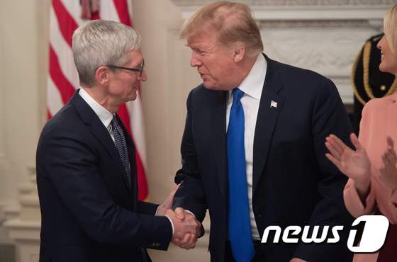 팀 쿡 애플 CEO(왼쪽)와 도널드 트럼프 미국 대통령이 악수를 나누고 있다. <자료사진> © AFP=뉴스1