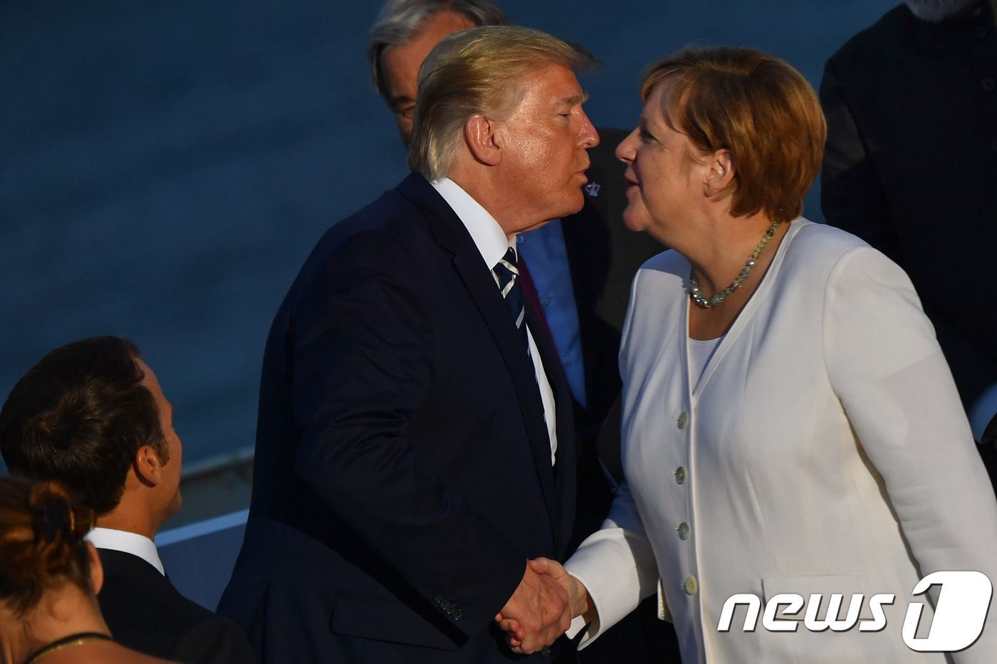 본문 이미지 - 도널드 트럼프 미국 대통령이 2019년 12월 25일(현지시간) 프랑스 비아리츠에서 열린 G7 정상회의의 단체사진 촬영 중 앙겔라 메르켈 독일 총리와 악수하며 키스를 하고 있다. ⓒ AFP=뉴스1 ⓒ News1 우동명 기자