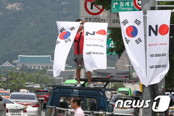 6일 오전 서울 중구 세종대로 일대에서 중구청 관계자들이 태극기와 '노 재팬' 배너깃발을 설치하고 있다. © News1 민경석 기자