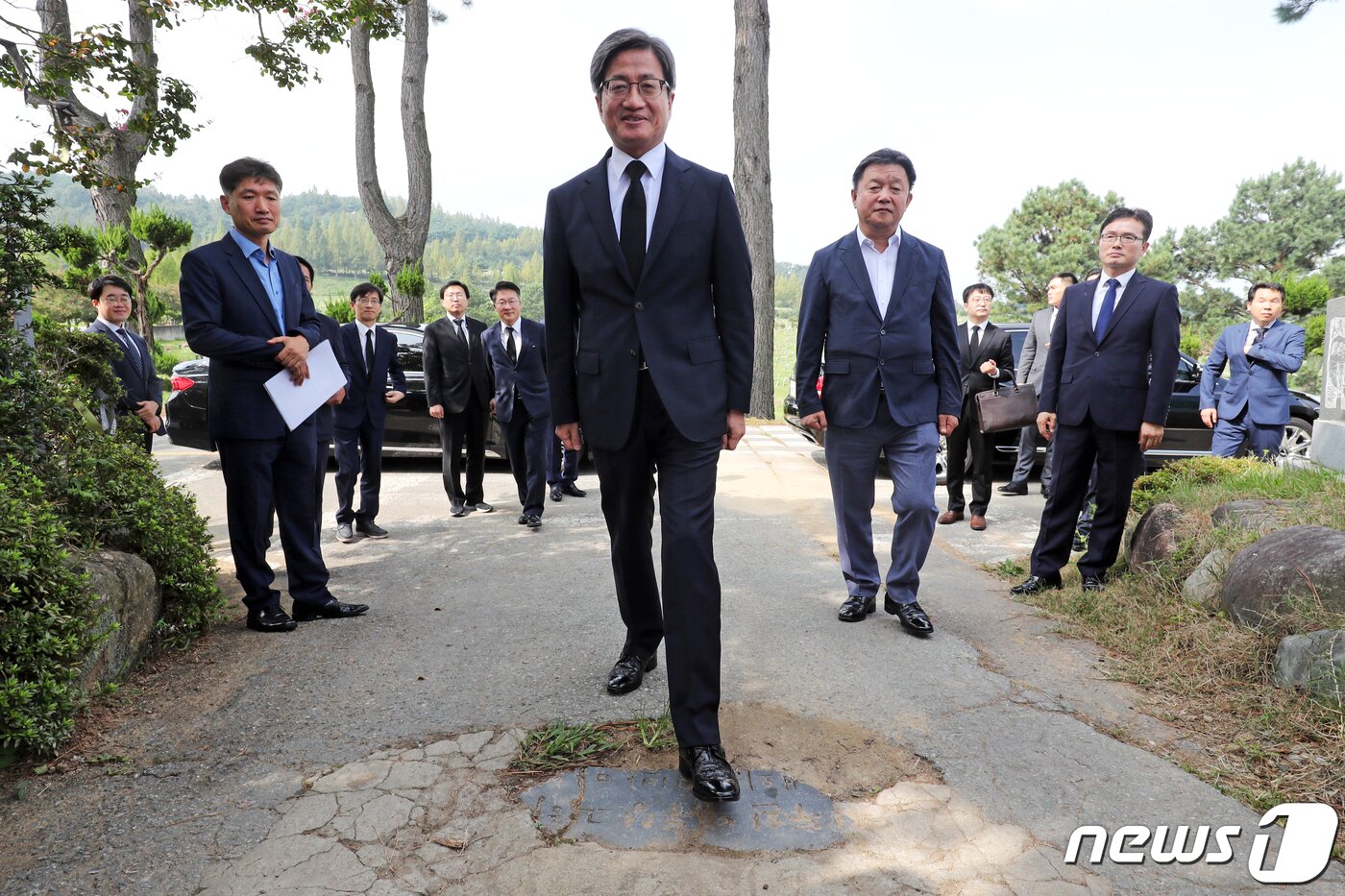 본문 이미지 - 2019년 9월16일 김명수 대법원장이 광주 북구 망월동 민족민주열사묘역(5·18 구 묘역)을 찾아 바닥에 설치된 전두환 전 대통령 기념비석을 밟고 지나가고 있다. 2019.9.16/뉴스1 ⓒ News1 황희규 기자