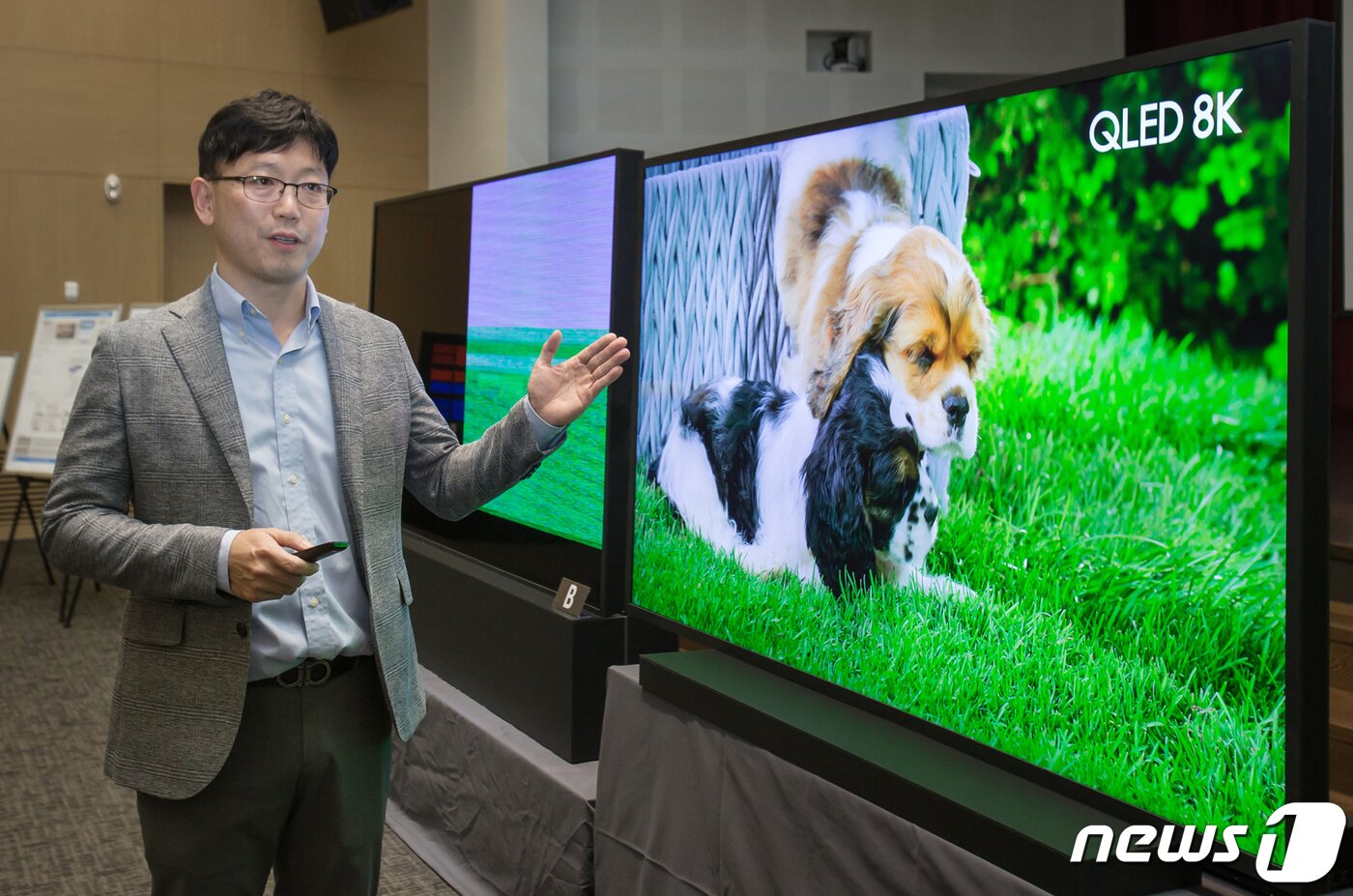 본문 이미지 - 용석우 삼성전자 영상디스플레이사업부 상무가 17일 오후 서울 서초구 R&D 캠퍼스에서 열린 8K TV 기술설명회에서 타사 8K TV와 비교 설명하고 있다.  좌측에 화면이 깨져 나타나는 것이 LG전자의 88인치 8K 올레드 TV이며 그 옆에는 삼성전자의 82인치 QLED 8K TV다. (삼성전자 제공) 2019.9.17/뉴스1