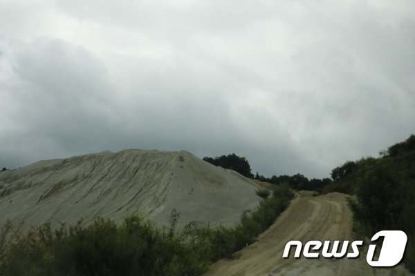 신고지역을 벗어난 목장용지 골재 파쇄 중에 발생한 석분들을 비닐 등으로 제대로 덮지도 않은 채 거대한 산처럼 쌓아 놓은 모습.ⓒ 뉴스1 송규복 기자