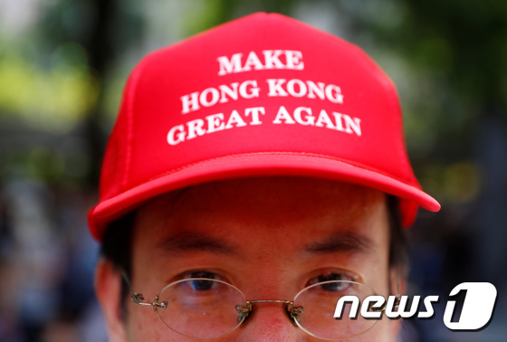 한 시민이 트럼프 대통령의 모자를 패러디한 모자를 쓰고 있다. © 로이터=뉴스1