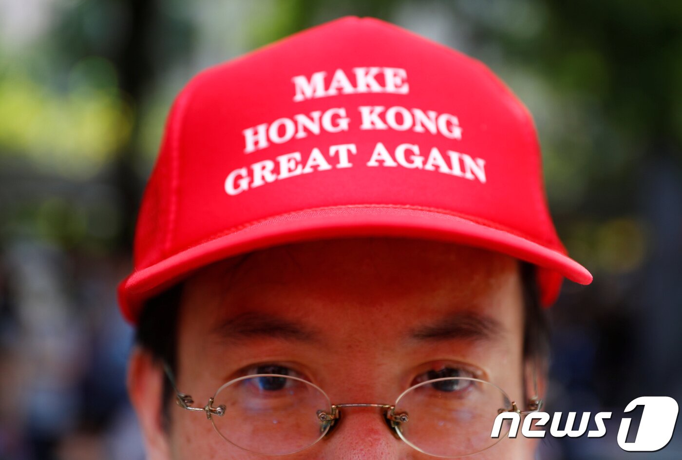 본문 이미지 - 한 시민이 트럼프 대통령의 모자를 패러디한 모자를 쓰고 있다. ⓒ 로이터=뉴스1