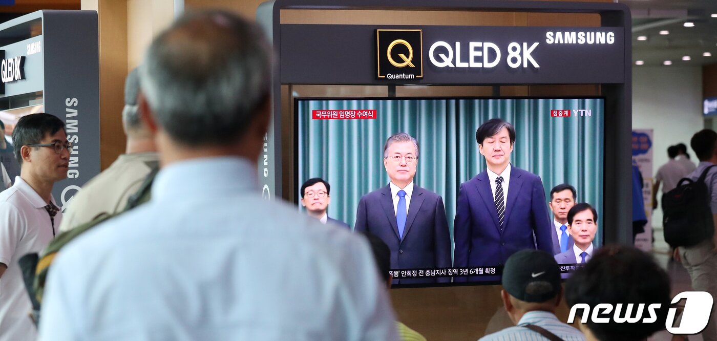본문 이미지 - 9일 오후 서울 용산구 서울역 대합실에서 시민들이 조국 신임 법무부 장관 임명장 수여식을 TV 생중계를 통해 지켜보고 있다. 2019.9.9/뉴스1 ⓒ News1 민경석 기자