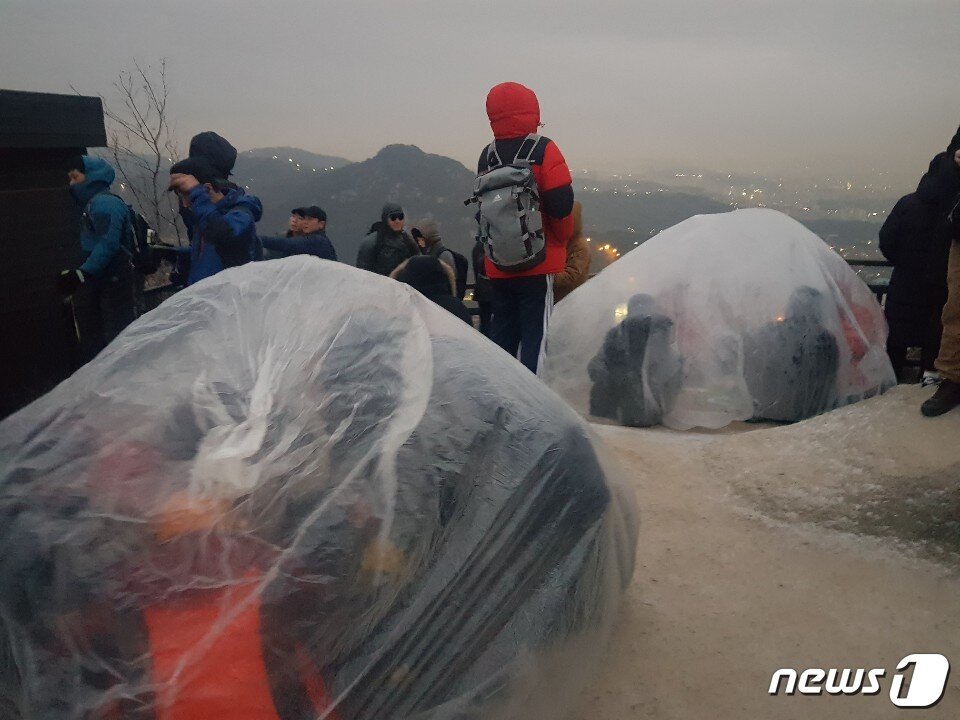 본문 이미지 - 청운공원 해돋이 보러온 시민들. 추위에 비닐 움막을 만들어 몸을 녹이고 있다 ⓒ 뉴스1 문성대 기자