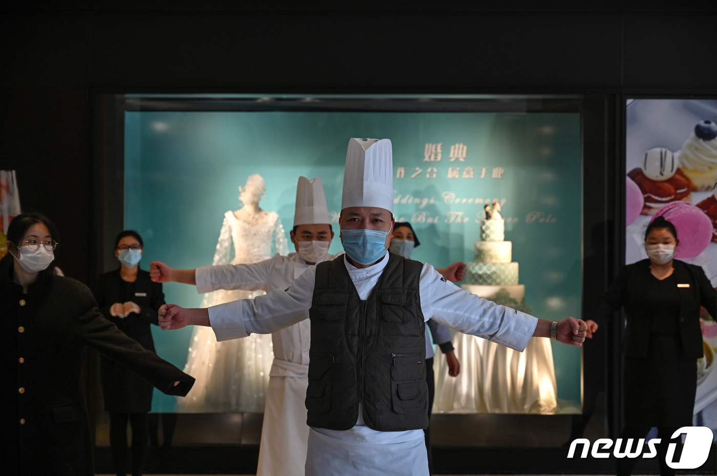 (우한 AFP=뉴스1) 정윤미 기자 = 28일(현지시간) 중국 우한의 한 호텔 종업원들이 신종 코로나바이러스를 예방하기 위해 마스크를 착용한 채 로비에서 체조를 하고 있다.ⓒ AF …