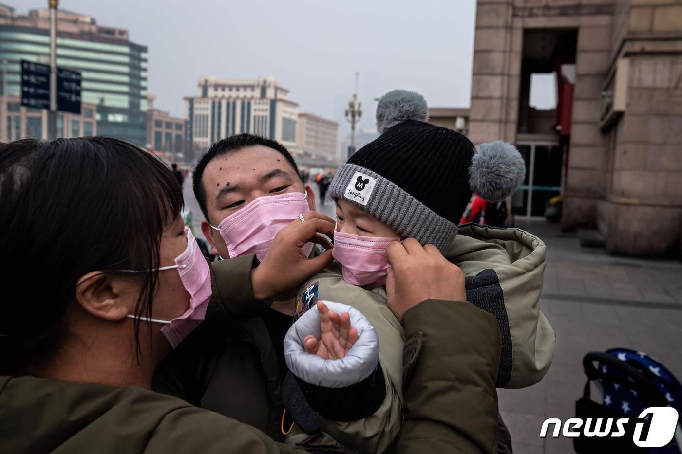 본문 이미지 - 어린 자녀의 마스크를 고쳐주는 중국 우한의 어머니 <자료 사진> ⓒ AFP=뉴스1