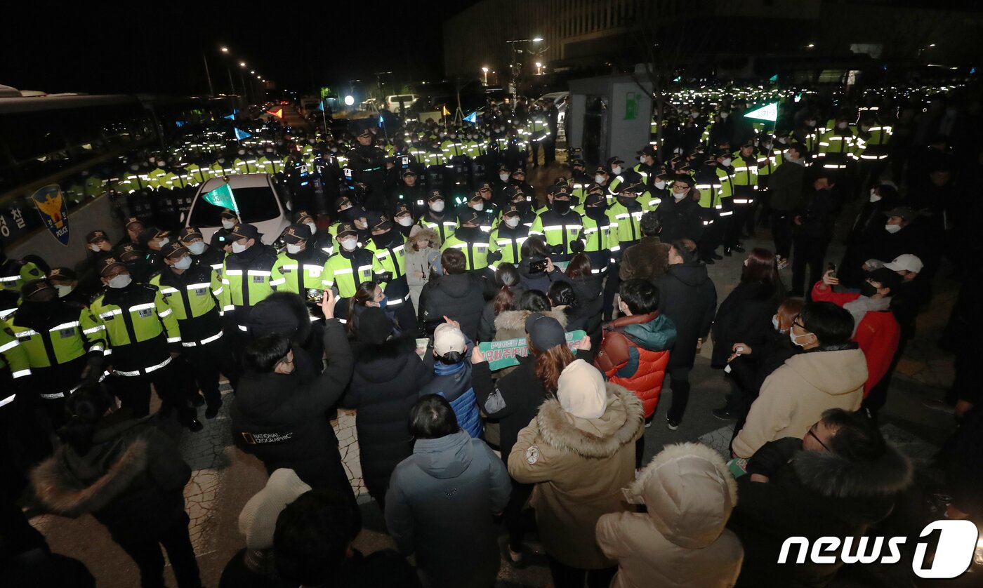 본문 이미지 - 충북 진천군민들이 29일 밤 우한 교민들이 수용될 진천 국가공무원 인재개발원 앞에서 경찰들과 대치하고 있다. 정부는 이날 충남 아산시에 위치한 '경찰인재개발원'과 진천군 국가공무원인재개발원 2곳에 우한에서 귀국을 희망하는 한국인 720명을 분산 수용하겠다고 발표했다. 2020.1.29/뉴스1 ⓒ News1 김용빈 기자