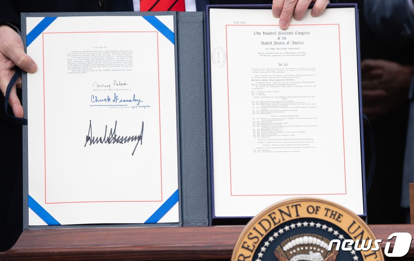 본문 이미지 - 도널드 트럼프 미국 대통령이 워싱턴 백악관에서 기존 북미자유무역협정(NAFTA)을 대체하는 새 북미무역협정인 미국·멕시코·캐나다 협정(USMCA) 서명문서을 들고 있다. ⓒ AFP=뉴스1 ⓒ News1 우동명 기자