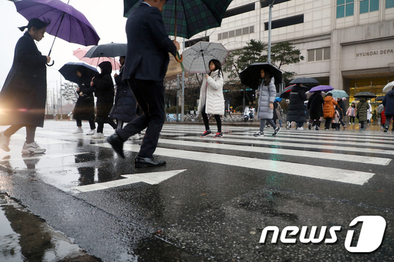 겨울비가 내린 7일 오후 서울 양천구 축제의 거리 앞에서 우산을 쓴 시민들이 발걸음을 옮기고 있다. 기상청 관계자는 