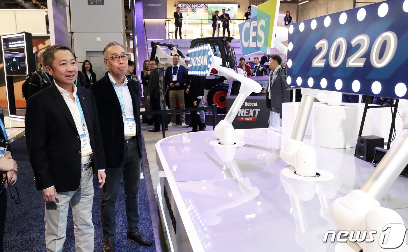 본문 이미지 - 국제가전전시회 'CES 2020'(Consumer Electronics Show) 개막 이틀째인 8일(현지시간) 미국 네바다주 라스베이거스 컨벤션센터 두산 전시장에서 박정원 두산그룹 회장(왼쪽)과 박지원 두산중공업 회장이 두산로보틱스 협동로봇의 사인 스피닝(Sign Spinning) 퍼포먼스를 지켜보고 있다. 두산그룹이 CES에 참가한 것은 이번이 처음이다. 2020.1.9/뉴스1 ⓒ News1 오대일 기자