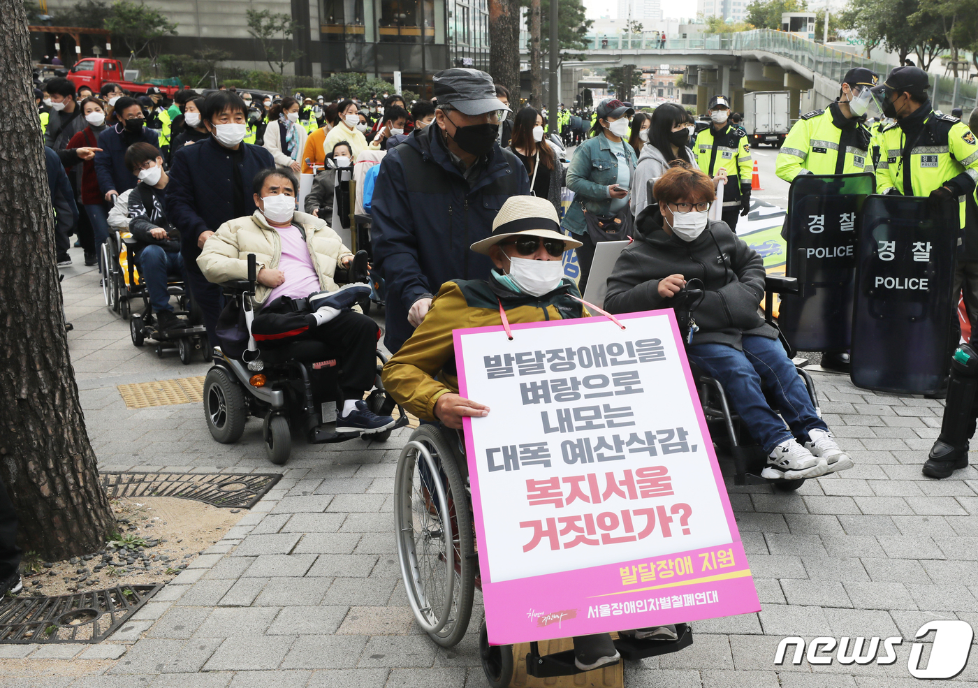 (서울=뉴스1) 송원영 기자 = 전국장애인차별철폐연대(전장연) 회원들이 15일 오후 서울 중구 서울역에서 서울시청 별관 방향으로 교통약자이동편의증진법 전면 개정을 촉구하며 행진을 …