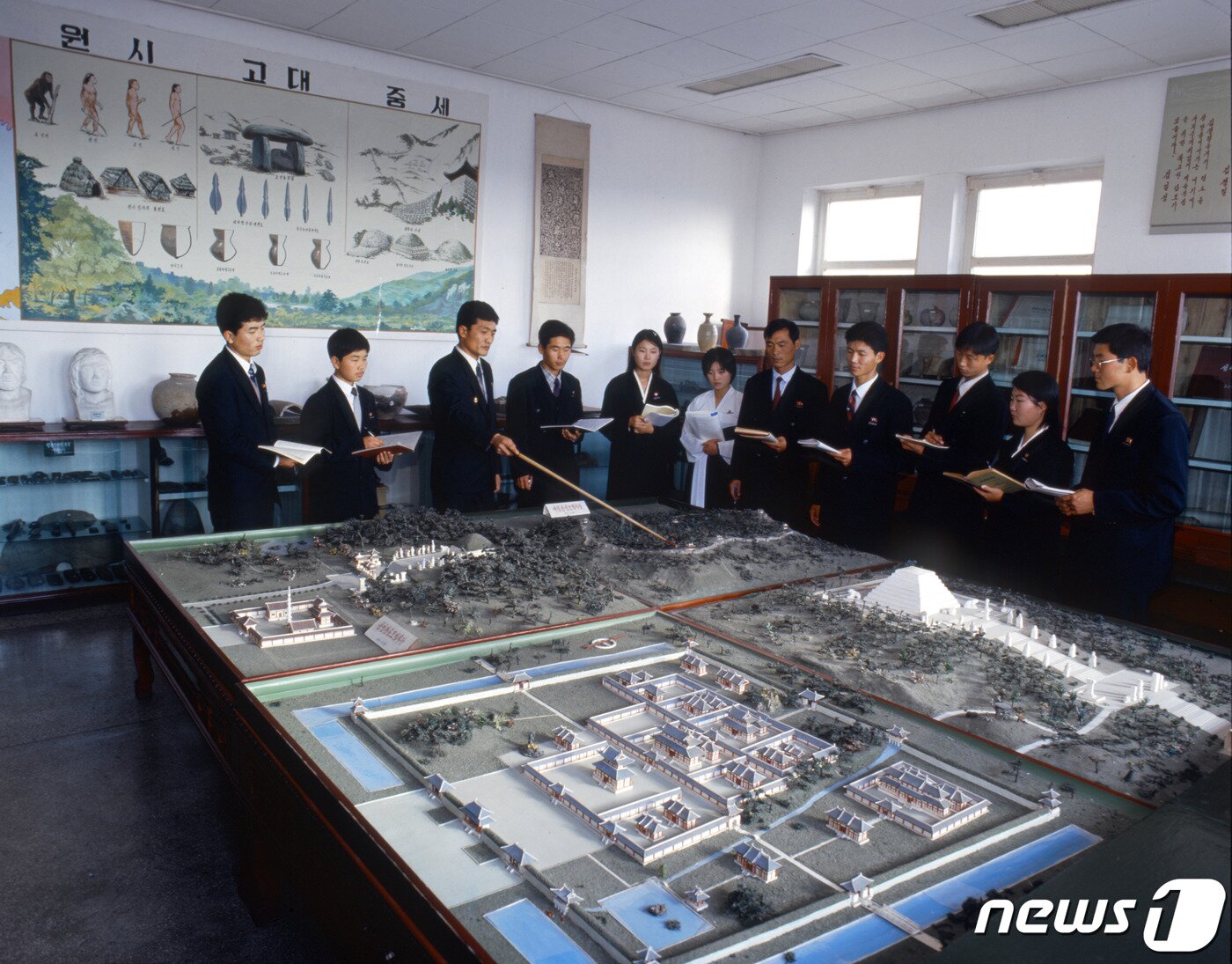 본문 이미지 - (서울=뉴스1) 김일성종합대학 역사학부 학생들이 대성산성, 왕건릉, 단군릉, 안학궁의 복원모형을 보며 수업을 하고 있다. 가장 아래 쪽 모형도가 안학궁이다. (미디어한국학 제공) 2020.10.17./뉴스1 photo@news1.kr