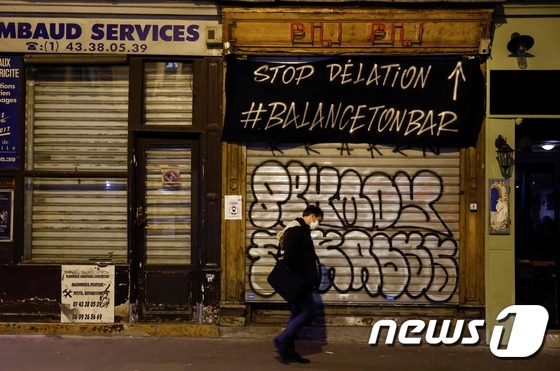 지난 6일 프랑스 파리에서 마스크를 착용한 한 남성이 문이 닫힌 술집 앞을 지나고 있다.© AFP=뉴스1
