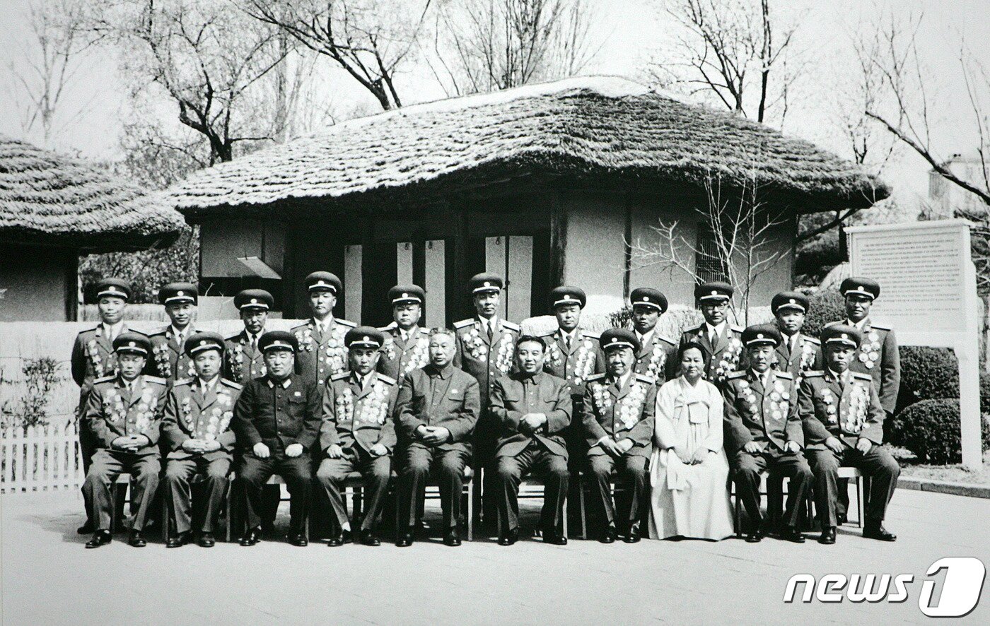 본문 이미지 - 1972년 4월 북한의 1세대 주요간부들이 김일성 주석의 환갑을 맞아 2세대 주요 간부들이 지켜보는 가운데 ‘만경대고향집’에서 기념촬영을 하고 있다.&#40;사진 제공: 미디어한국학&#41;ⓒ 뉴스1