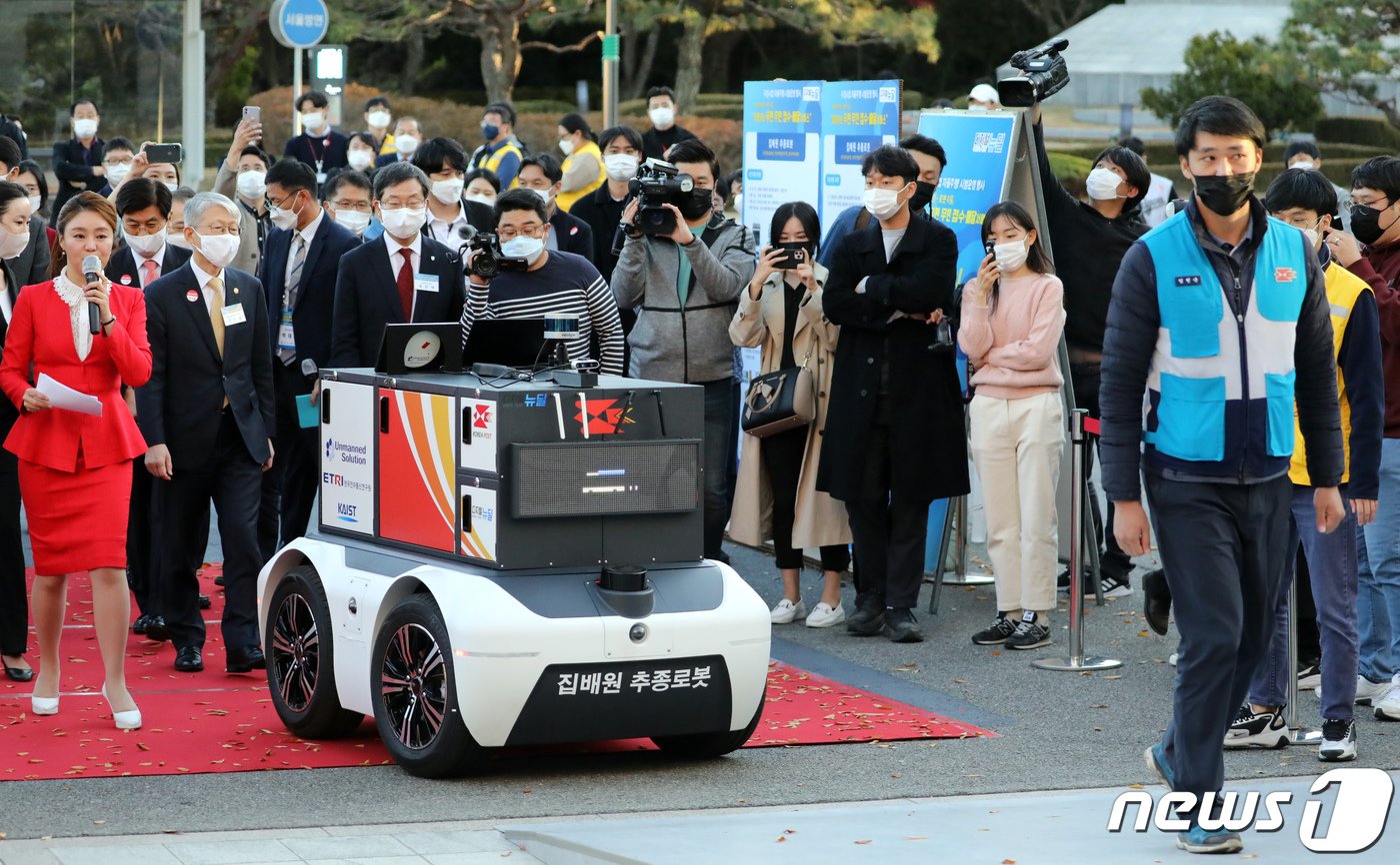 본문 이미지 - 세종시 조치원읍 고려대 세종캠퍼스에서 열린 우정사업 자율주행 시연 행사에서 고중량의 소포를 적재한 집배원 추종로봇이 집배원 뒤를 따라 배송 보조 역할을 수행하고 있 2020.10.28/뉴스1 ⓒ News1 장수영 기자