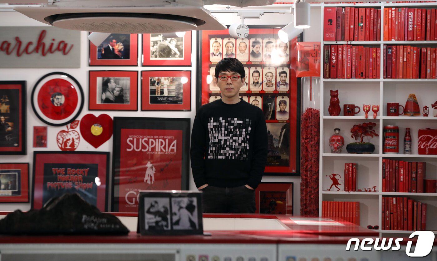 본문 이미지 - '레드존'으로 꾸며진 파이아키아 한쪽 벽면에 이동진이 서있다./뉴스1 ⓒ News1 황기선 기자