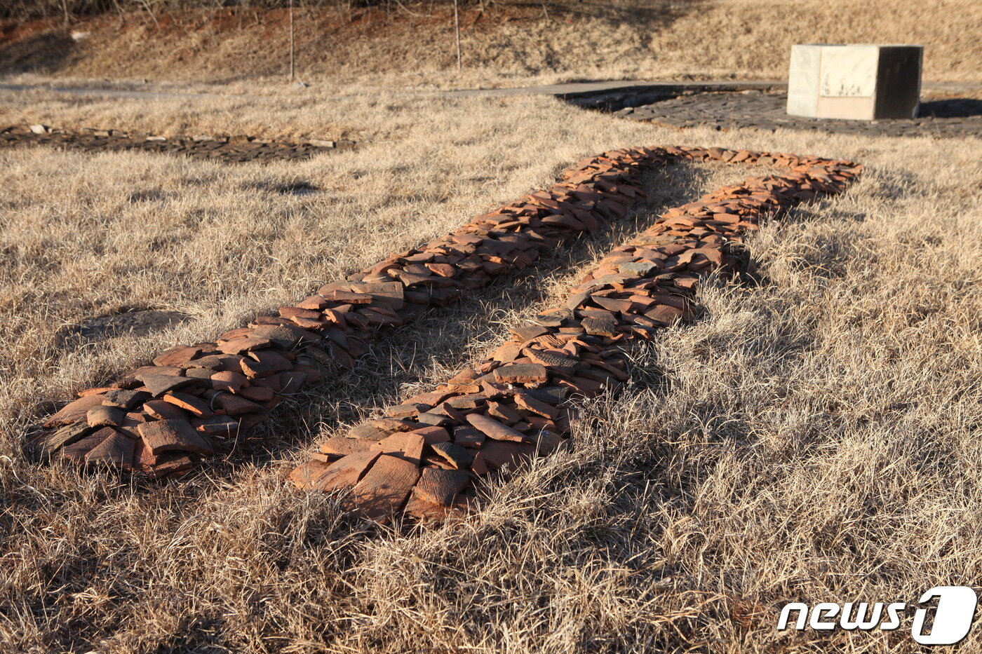 본문 이미지 - 1974년 북한이 복원한 정릉사 보광전 뒤쪽에 있는 고구려시기 우물과 출토 기와 조각들. (미디어한국학 제공) 2020.11.14.ⓒ 뉴스1