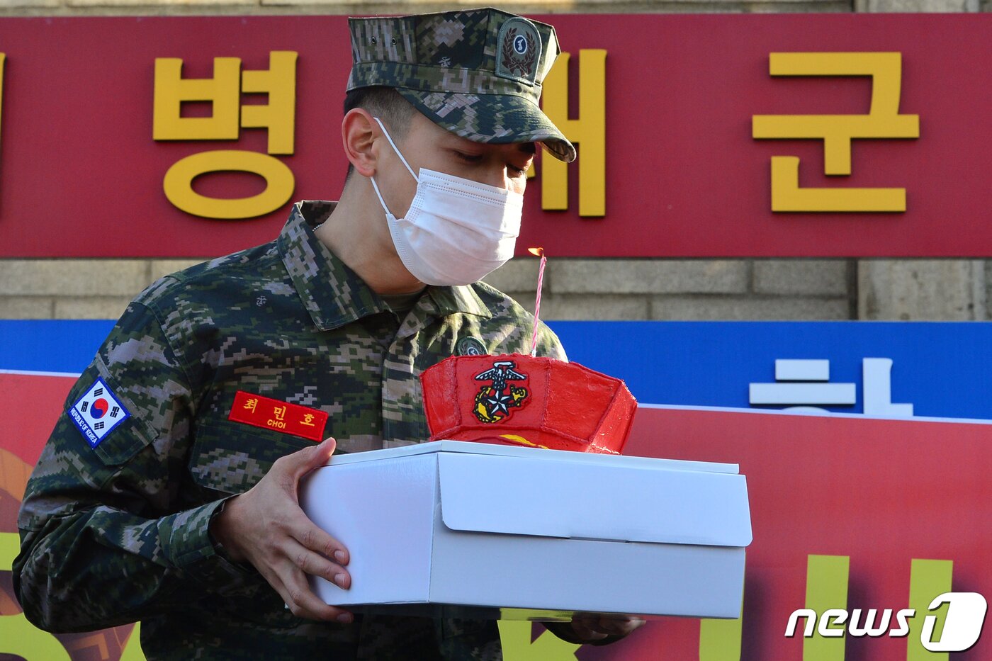본문 이미지 - 해병대 병장으로 전역한 샤이니 민호가 15일 오전 경북 포항시 남구 해병대 서문을 나서며 팬들에게 받은 케이크 촛불을 끄고 있다. 민호는 2020 호국훈련에 참가하기 위해 20일간의 전역 휴가를 반납했다. 2020.11.15/뉴스1 ⓒ News1 최창호 기자