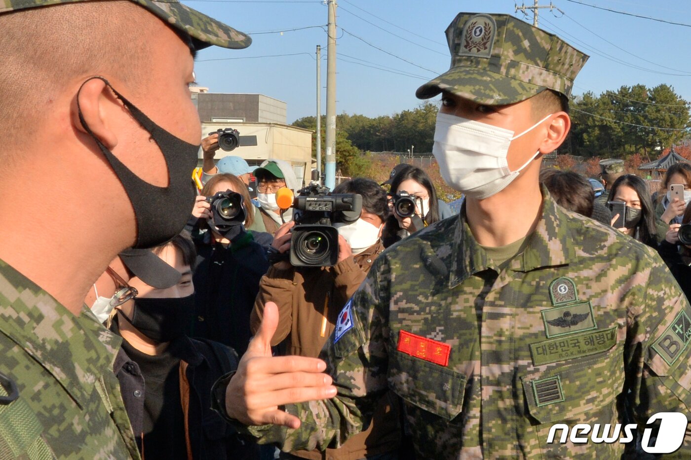 본문 이미지 - 해병대 병장으로 전역한 샤이니 민호가 15일 오전 경북 포항시 남구 해병대 서문 앞에서 후배 해병들과 인사를 나누고 있다. 최 병장은 10월27일 전역 전 휴가 후 11월15일 휴가 상태에서 전역할 예정이었지만 휴가 기간 중 시행되는 2020호국훈련에 참가하기 위해 20일간의 전역 휴가를 반납했다.2020.11.15/뉴스1 ⓒ News1 최창호 기자